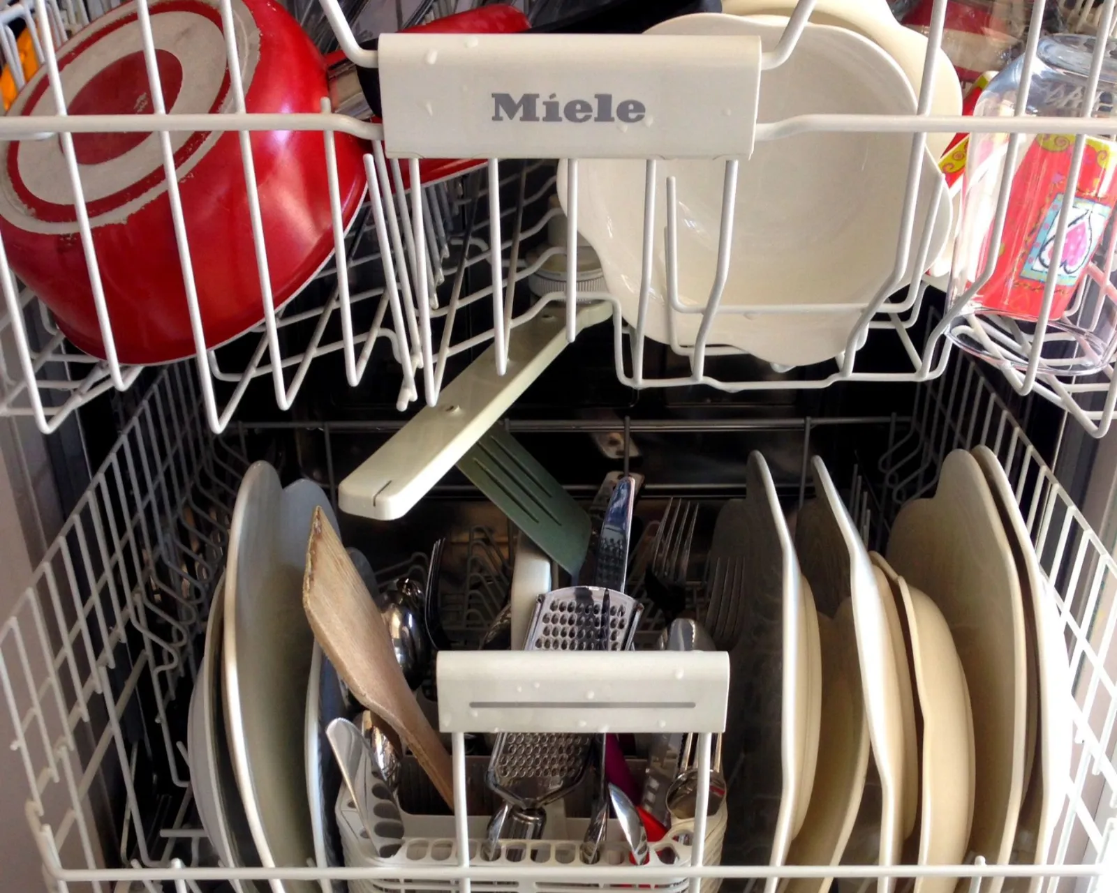 Dishwasher repair: loaded Miele dishwasher with plates and cookware